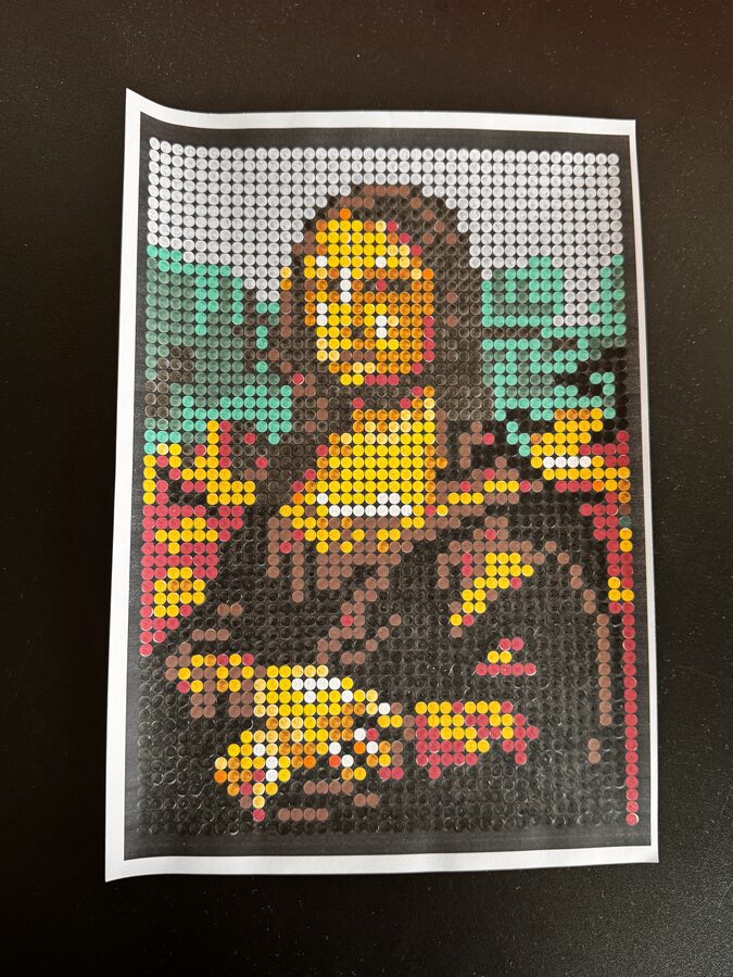 Ingekleurde versie van de Mona Lisa van Leonardo da Vinci in NOVI's colour-by-letter formaat — vrouwenportret met glimlach tegen landschapsachtergrond